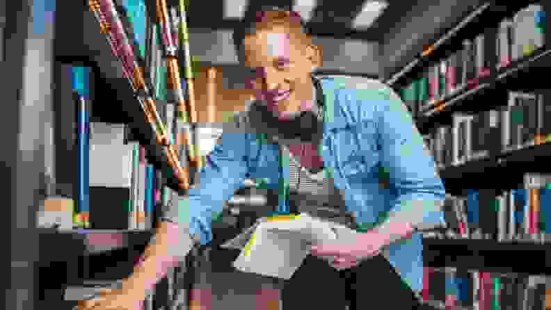 Young man in library looking at books