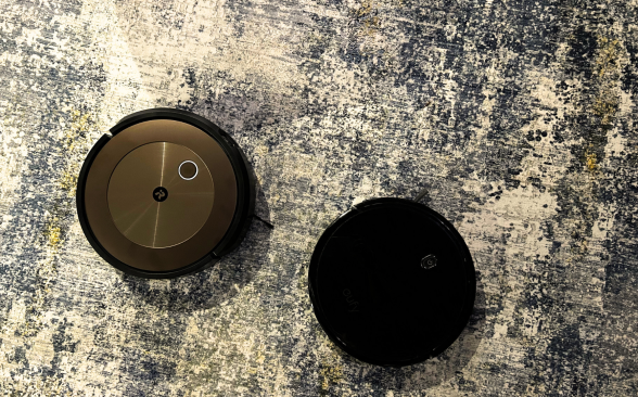 Two of the best robot vacuums sit on a gray rug