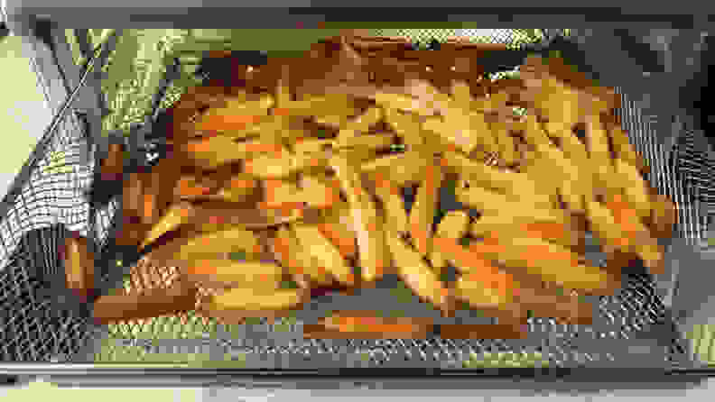 A tray of french fries emerging from the Ninja Foodi Air Fryer Oven.