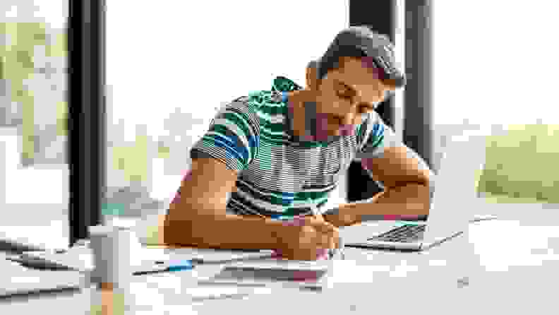 Man sitting at table with paperwork and computer