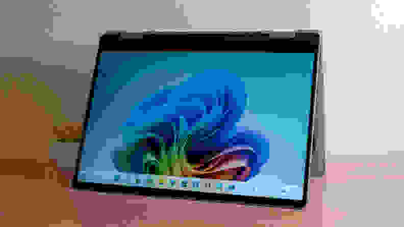 An open silver laptop sits on a brown desk