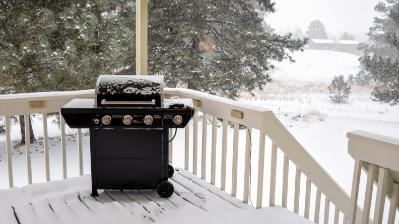 Outdoor grill on snowy deck during winter