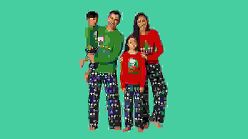 A family wearing Peanuts Matching Family Pajamas on a green background.