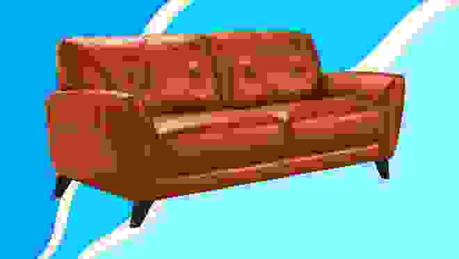 A tan leather couch against a blue background.
