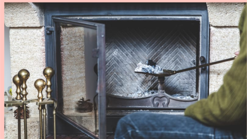 Person scooping hot ashes out of fireplace.