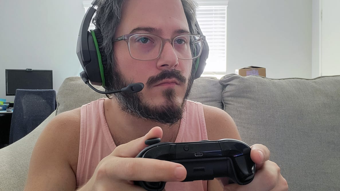 Man wearing the HyperX CloudX Stinger Core while holding an Xbox controller