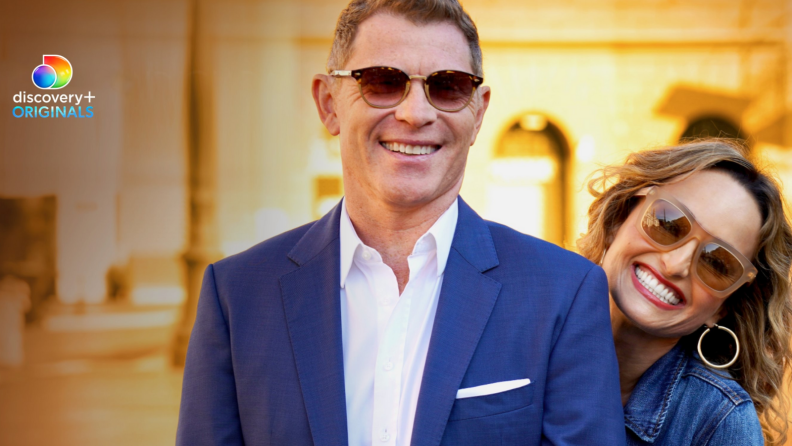 Celebrity chefs Bobby Flay and Giada De Laurentiis pose for the camera wearing sunglasses.