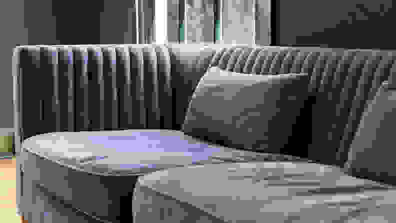 A grey couch in a dark green room