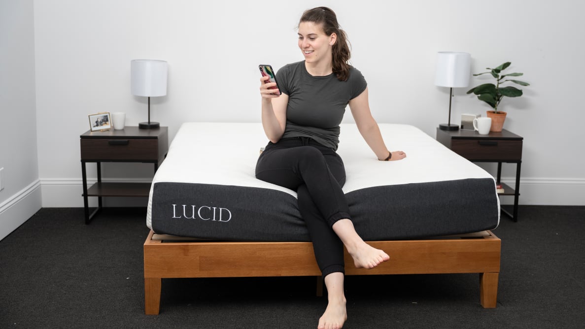 a person sits on the edge of the Lucid mattress
