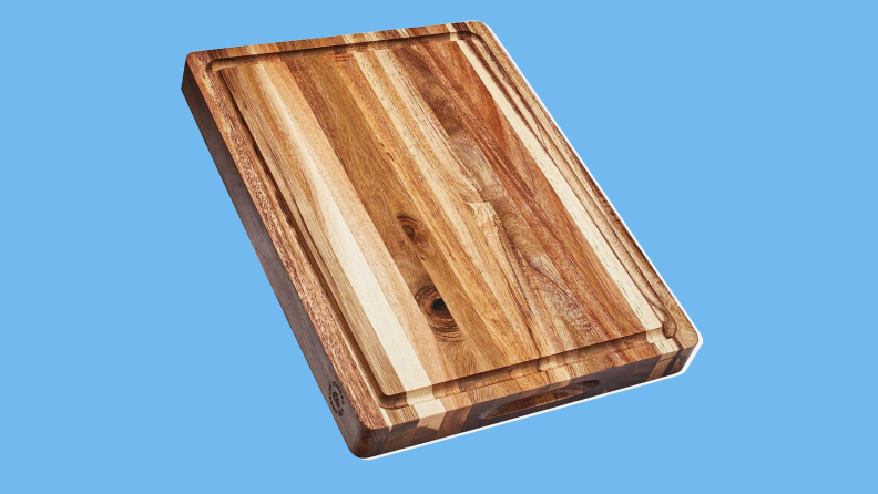 A Sonder LA wood cutting board on a blue background