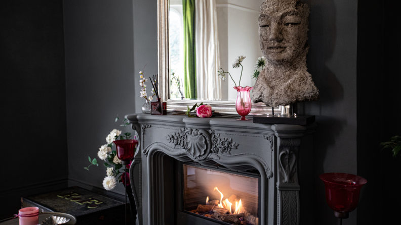 A dark living room with a fireplace and art.