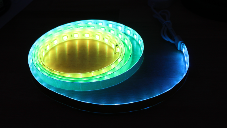The Govee M1  strip light illuminated in a dark room showing colors of yellow, green, and blue