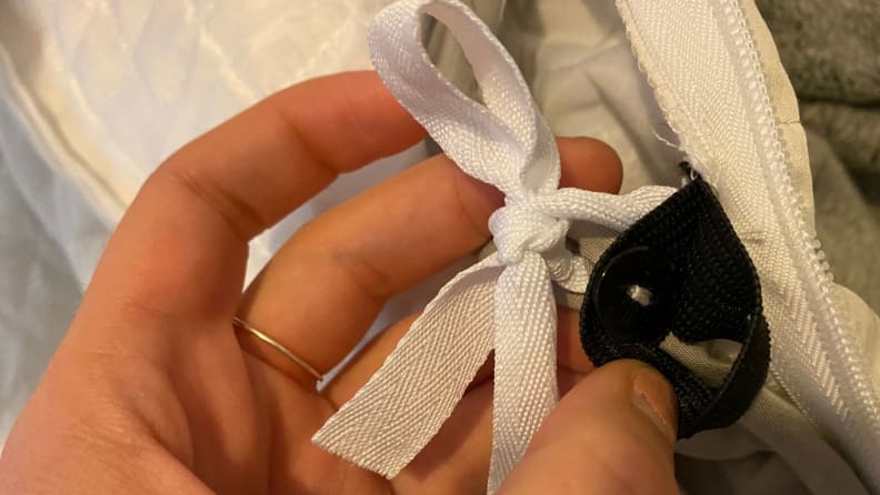 a hand holds the fastening mechanism of the gravity blanket