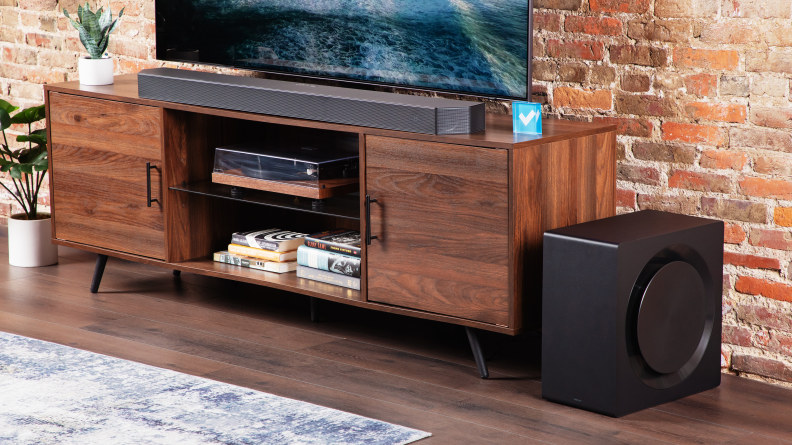 The Samsung HW-Q990C on a home theater credenza, with its sub placed to the side.