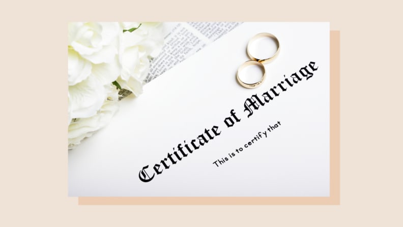 Certificate of marriage with gold wedding bands on top.
