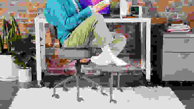 Person sitting comfortably in the Pipersong Meditation Chair while reading a book in front of desk.