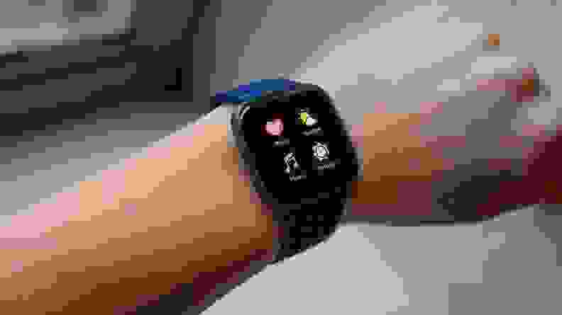 a wrist extended to show the home screen on a Fitbit