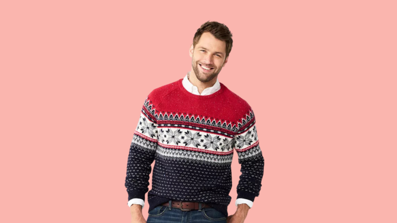 A man wears a red and black fair isle sweater.