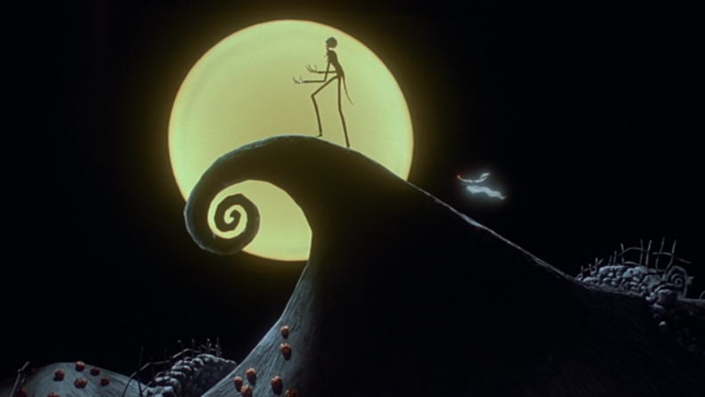 A still from 'The Nightmare Before Christmas' featuring Jack Skellington on a hill, silhouetted by a yellow moon.