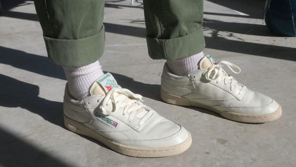 Pair of Reebok Club C 85 Vintage sneakers worn on man with green chino pants from Uniqlo.