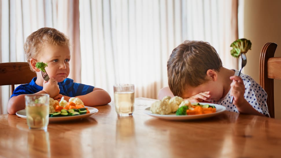 Two boys at a table refusing to eat