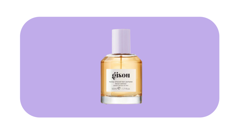Gisou hair perfume in front of a dark purple background.