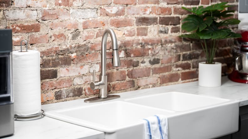 A silver faucet is attached to a white kitchen sink