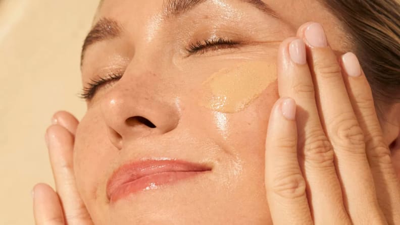 Model applies serum to face