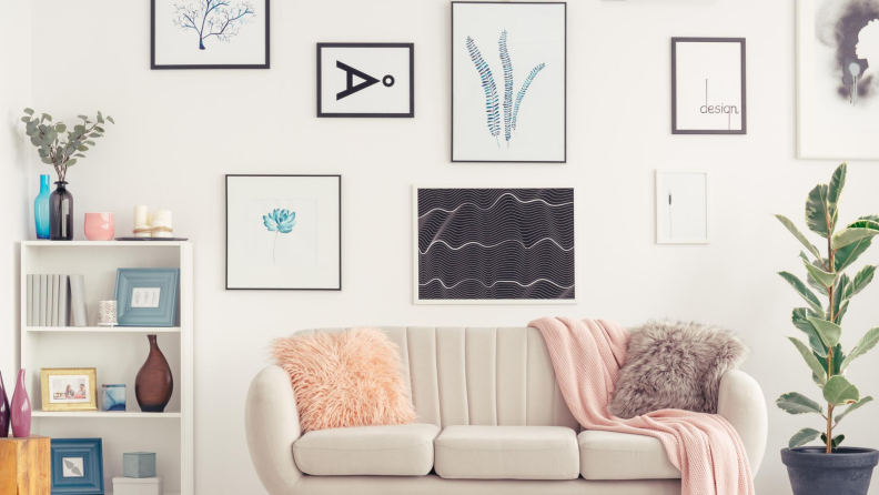 A collection of hanging wall art above a couch in a living room.