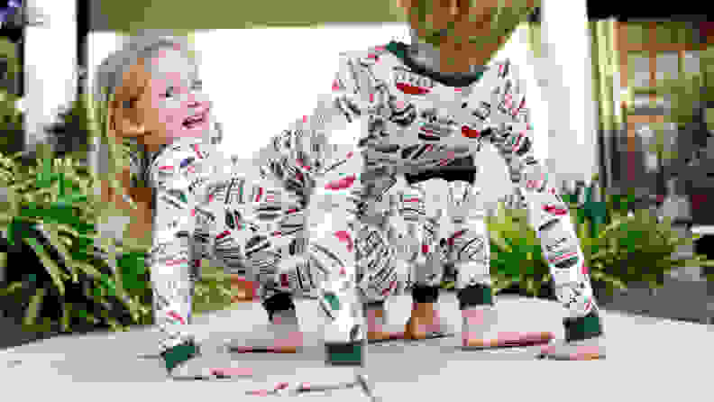 A girl and boy wearing matching pajamas playing outside