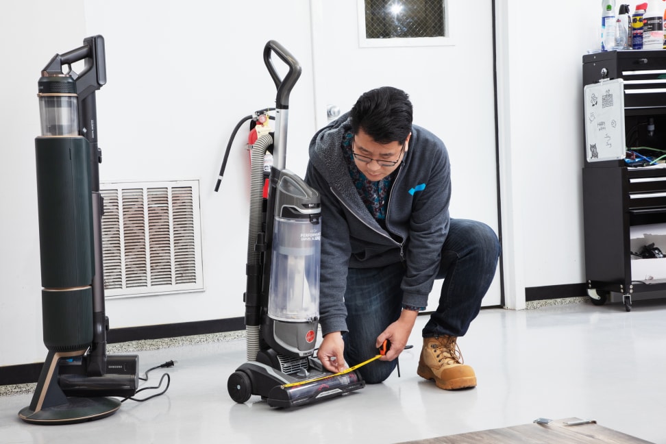 A man in a lab measuring the width of a vacuum.