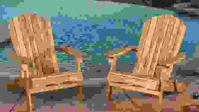 2 brown Adirondack chairs overlooking the water