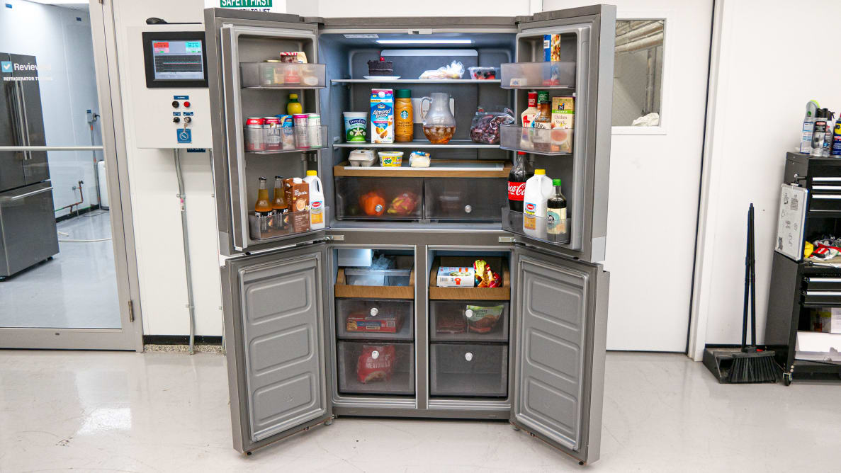 A four-door fridge completely open, showing all storage spaces filled with food.