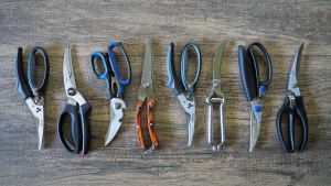 Eight sets of poultry shears on wooden surface