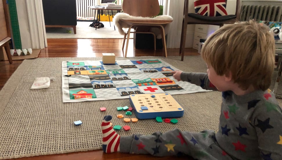 A toddler plays with Cubetto in the living room