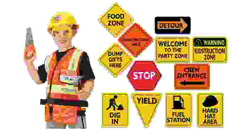 A child in a construction worker costume and a set of construction signs.