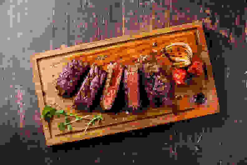 Sliced steak resting on a wooden cutting board