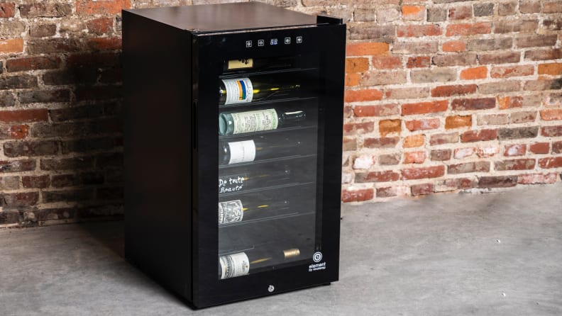 Refroidisseur à vin à écran tactile Vinotemp de 42 bouteilles devant un mur de briques, partiellement rempli de vin.