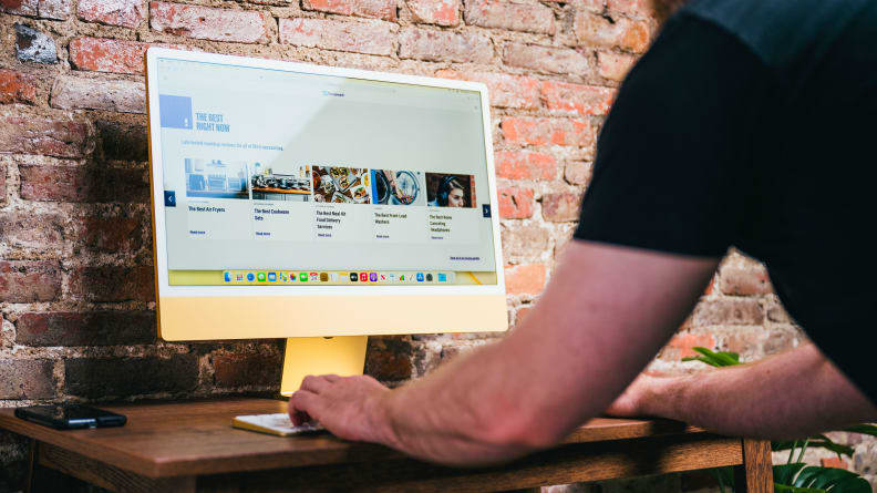 A person typing on a keyboard in front of a computer