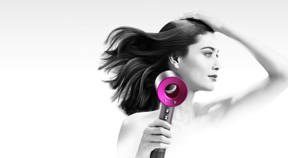 A woman blow dries her hair with the Dyson Supersonic hair dryer