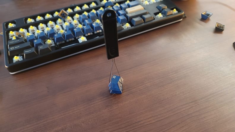 A keycap puller holding three keycaps