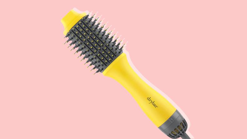 Drybar brush in front of a light pink background.