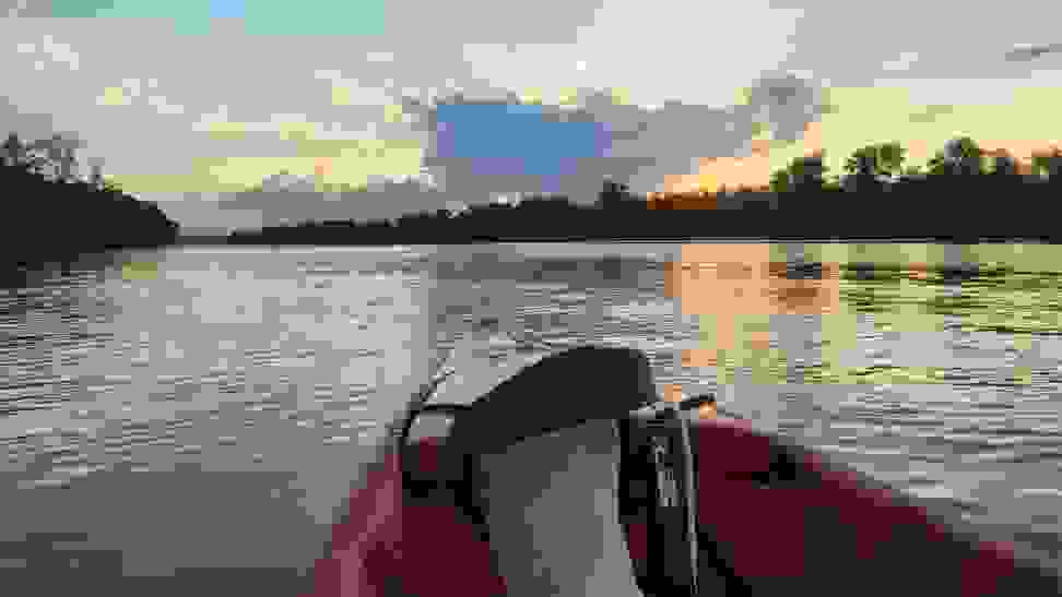 POV from seat of pedal kayak on a Missouri lake at dusk. Trees line the horizon.