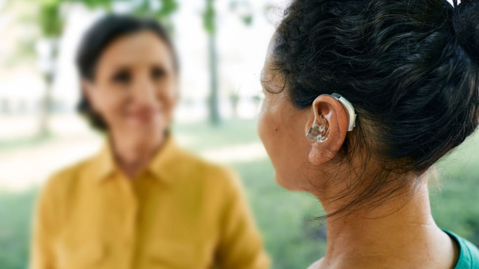 Person talking outdoors with another person outdoors.