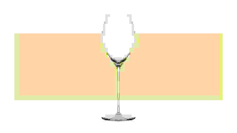 A single tulip-shaped champagne glass on a yellow background.