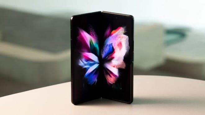 A Galaxy Fold sitting on a table against a mountain backdrop.