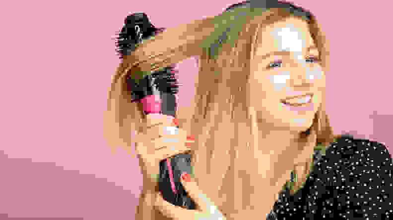 A photo of a woman using the Revlon One-Step Hair Dryer and Volumizer.