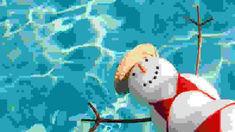 A snowman, clad in swimwear, floating in a swimming pool.