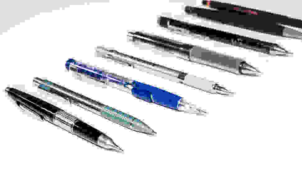 Eight mechanical pencils, sit in a row, on a white countertop.