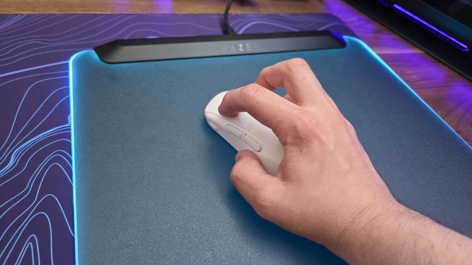 A hand gripping the Turtle Beach Burst II Air mouse on top of a purple and blue patterned mousepad.